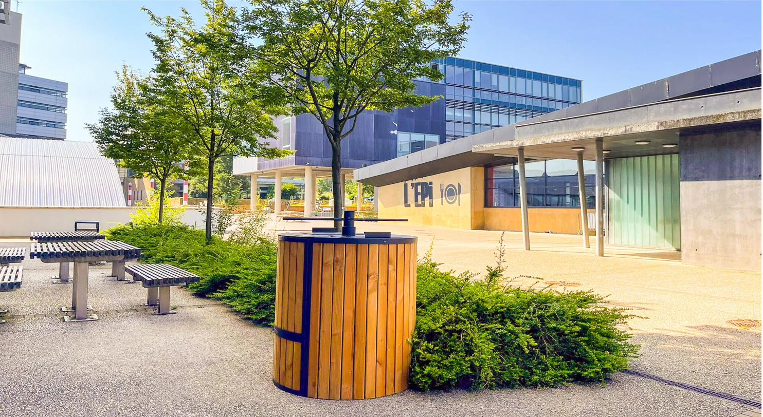 Komposter unter einem Baum vor einem modernen Gebäude