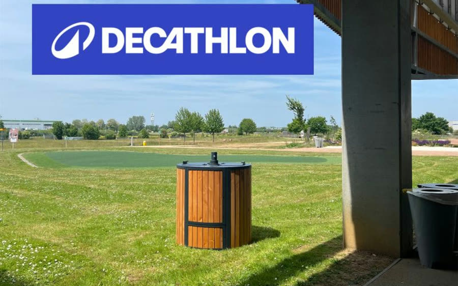 ABC composter clad in vertical douglas fir slats, with anthracite lacquered lid and bands, standing on the lawn at the back of a Decathlon store, a few metres from the building and with no connections at all.