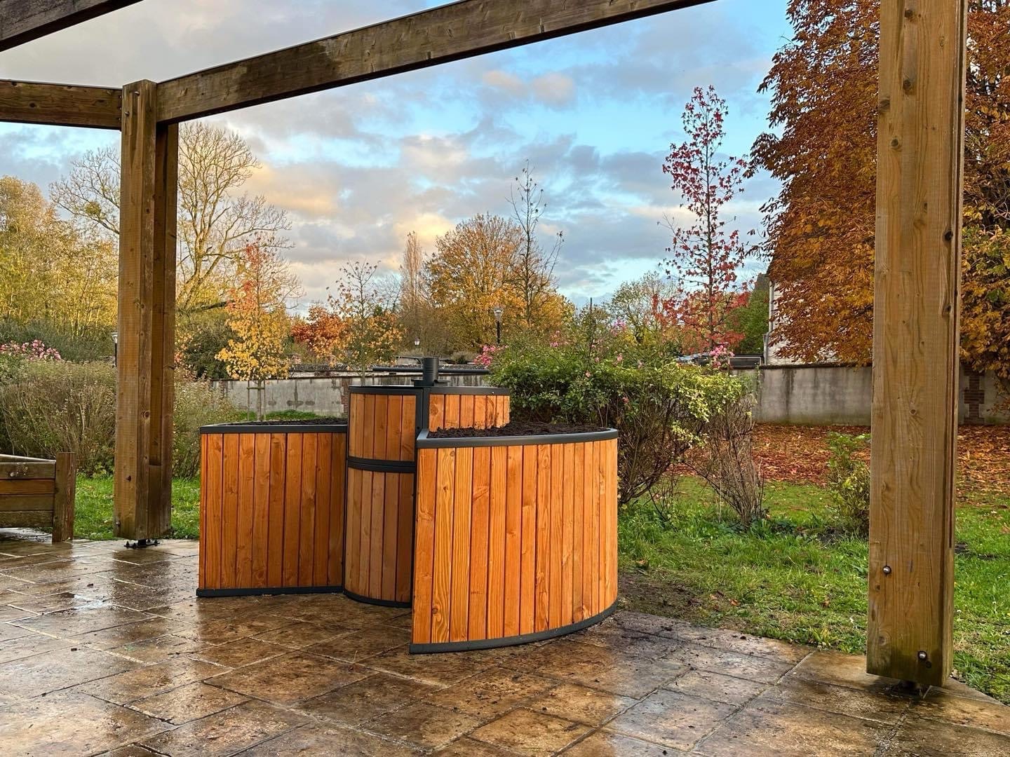 Garten-Komposter unter einer Pergola, an einem Herbstabend